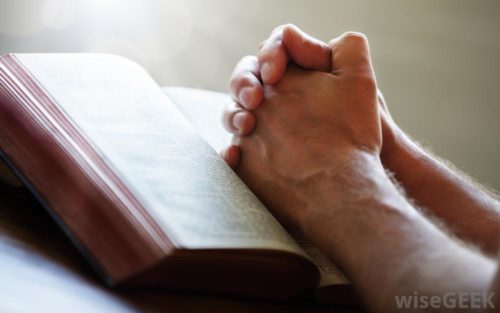 Praying hands on Bible